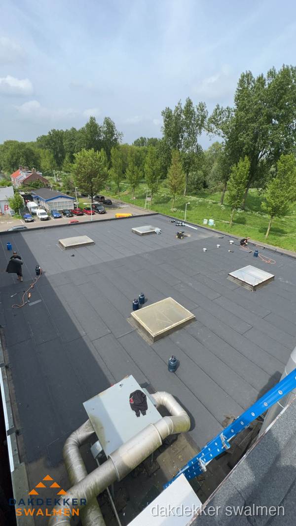 Dakdekker aan het werk op groot plat dak met bitumen in Swalmen Dakdekker aan het werk op groot plat dak met bitumen in Swalmen