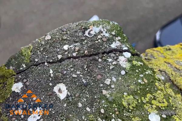 Beschadigde en verweerde nokvorst met scheuren en mos in Swalmen Beschadigde en verweerde nokvorst met scheuren en mos in Swalmen