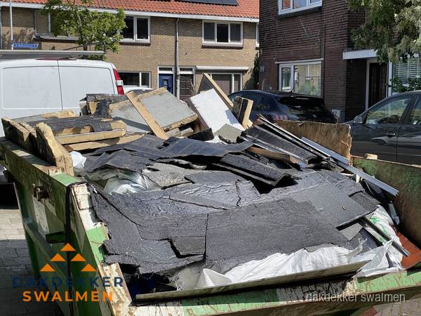 Afvalcontainer met gesloopt dakmateriaal tijdens dakkapel renovatie in Swalmen Afvalcontainer met gesloopt dakmateriaal tijdens dakkapel renovatie in Swalmen
