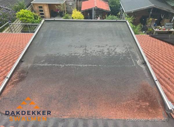 Verouderd plat dak met slijtage tussen schuine daken in Swalmen Verouderd plat dak met slijtage tussen schuine daken in Swalmen